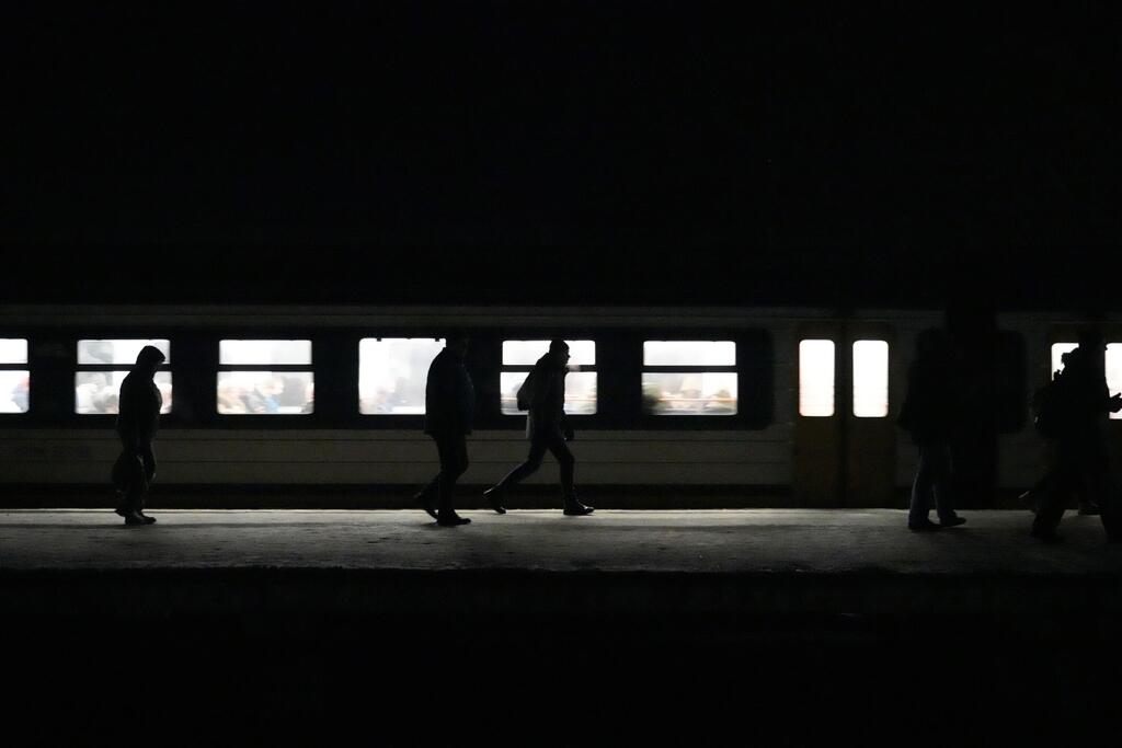 Les voyageurs se déplacent dans une gare pendant une panne d'électricité, illustrant comment les perturbations de l'approvisionnement en électricité peuvent rapidement affecter les transports, les communications et la vie quotidienne.